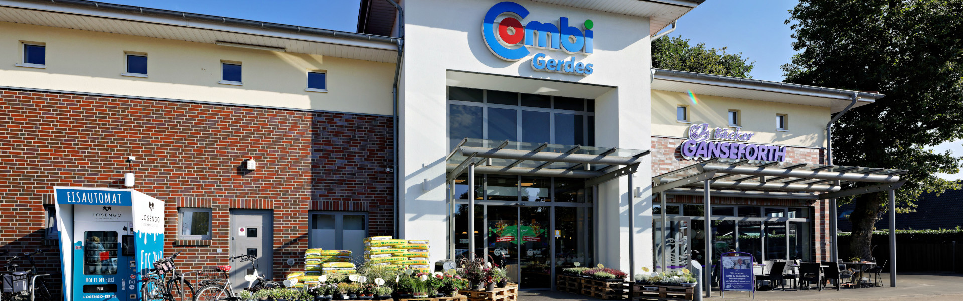 Außenansicht des Combi Gerdes Supermarkts mit Eingang und vorgelagerter Terrasse.