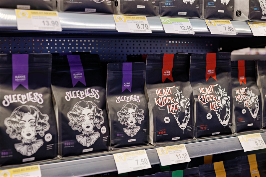 Kaffeeregal im Combi Markt mit schwarzen Kanne-Rösterei-Packungen „Sleepless“ und „Heart Knock Life“.