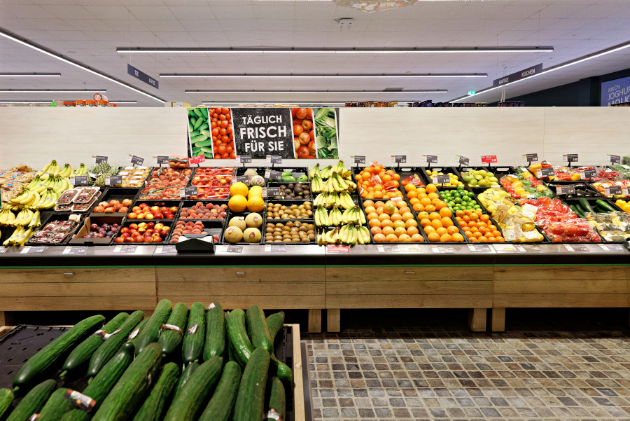Obst- und Gemüseabteilung mit „Täglich frisch“-Schild.